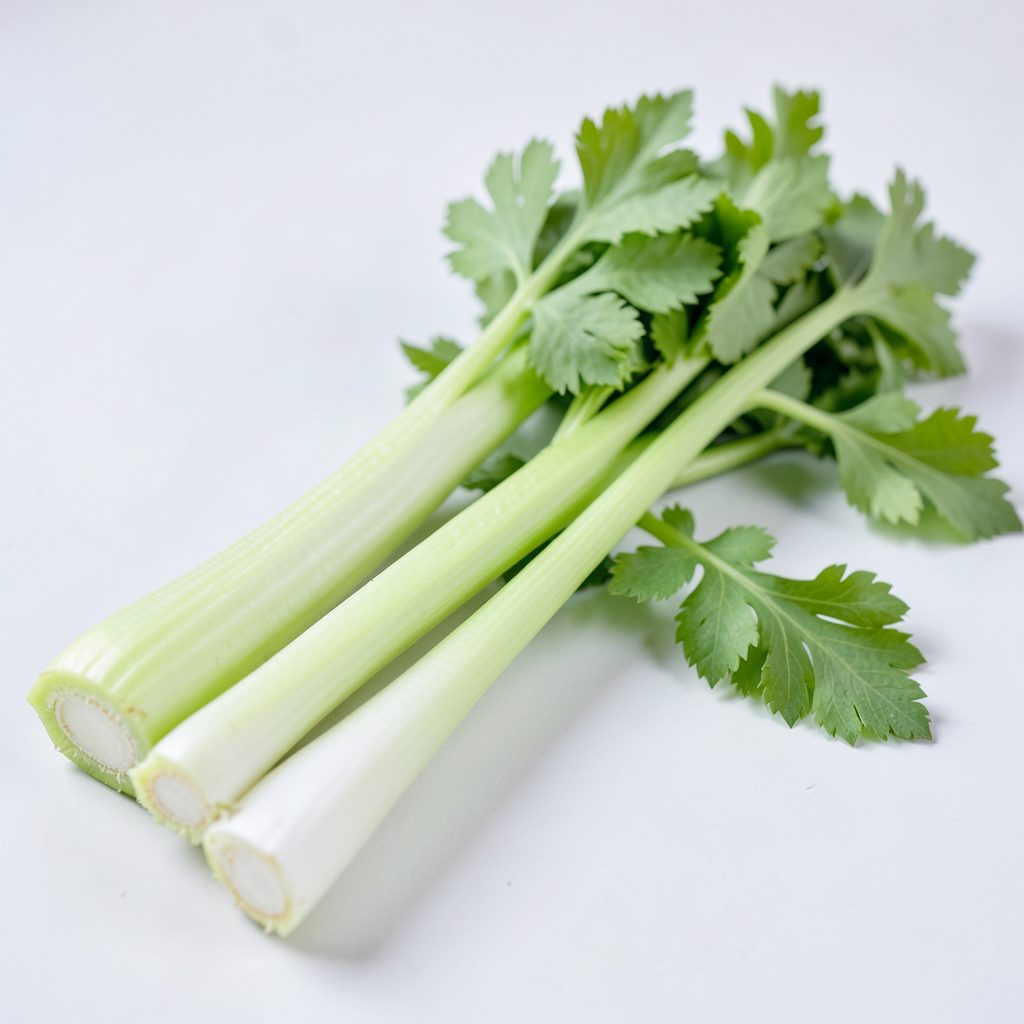 Fresh celery stalks with leafy tops on a white background, pale green and white colors, clean simple mood